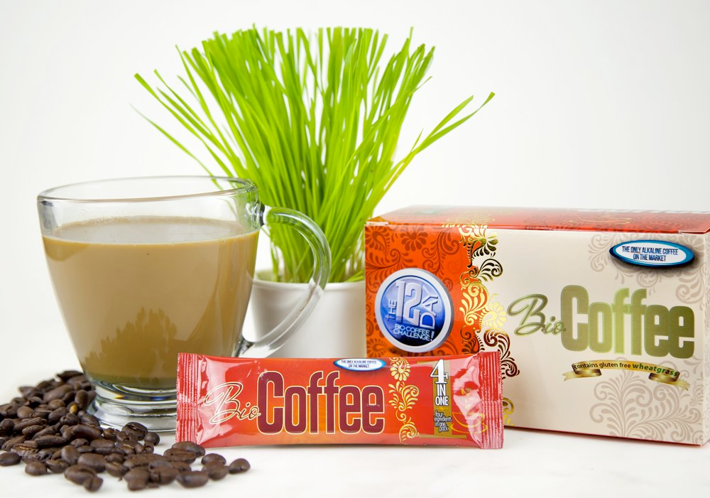 Bio Coffee Alkaline Coffee Packet and Box Next to Cup of Coffee and Lemon Grass Plant on a Table Top Edit alt text