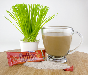 Bio Coffee Alkaline Coffee Packet  Next to Cup of Coffee and Lemon Grass Plant on a Table Top